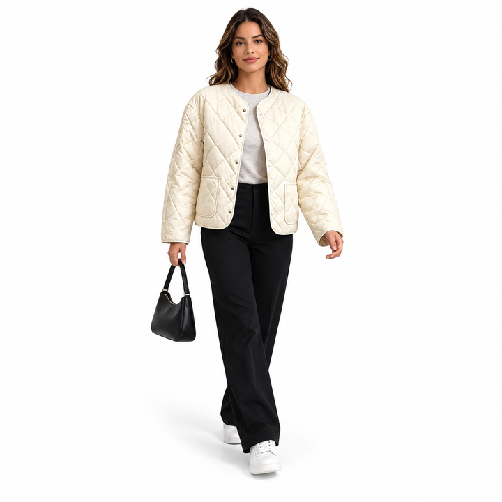 Off-white quilted jacket styled with black trousers and a small bag on a walking model