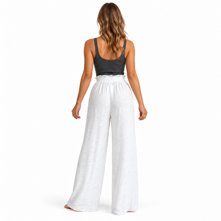 Back view of White crinkle trousers showing the gathered waistband and wide legs