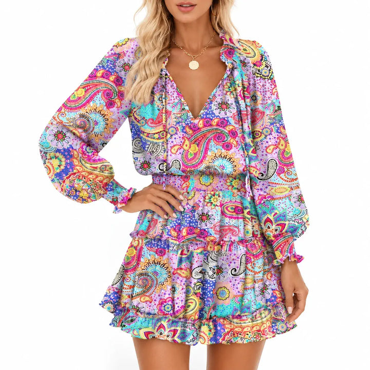 Lilac Paisley mini dress close-up showing vivid multicolor print, neckline ties, smocked waistband and gathered sleeve cuffs.