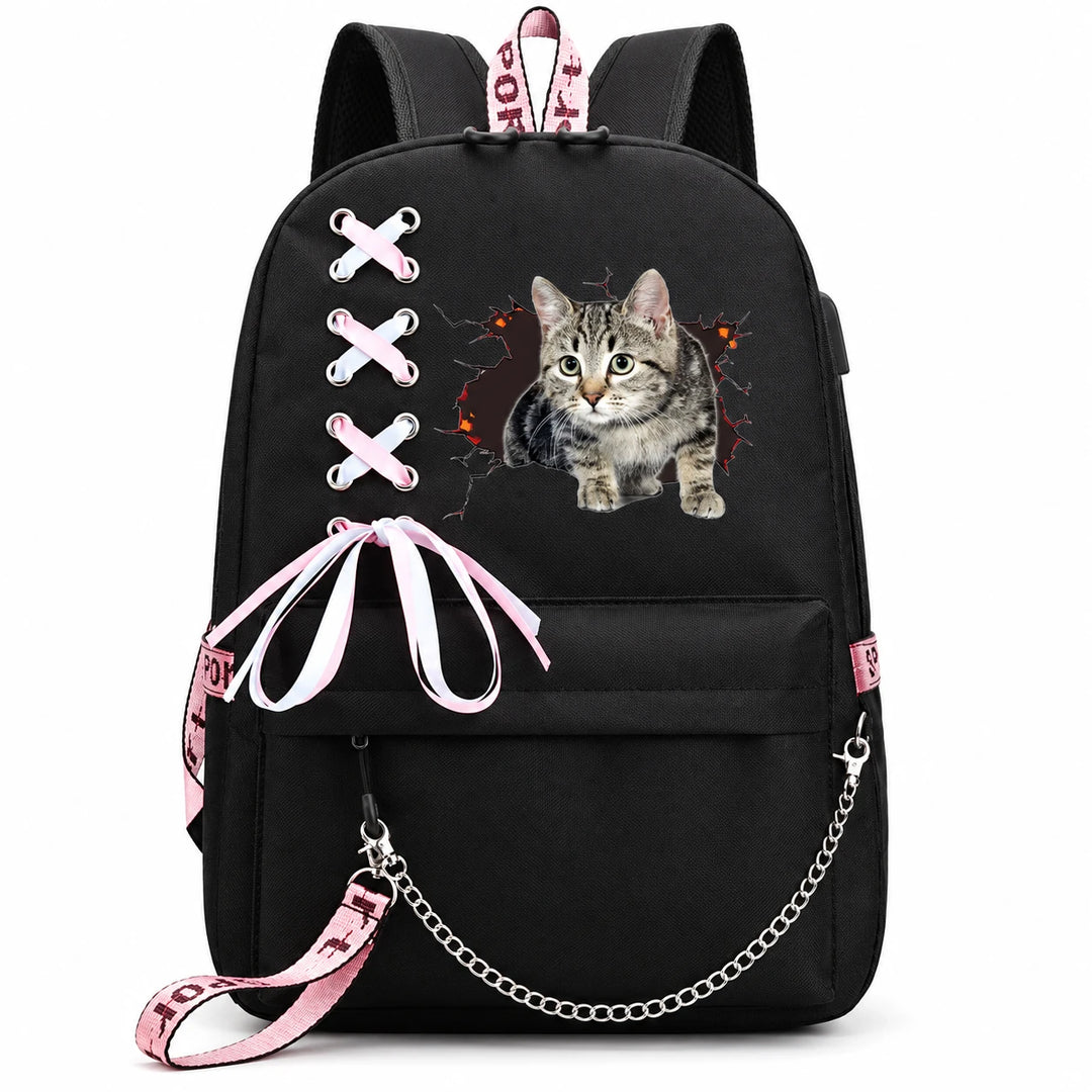 Black backpack with a standing tabby kitten and dark cracked opening design, with pink-and-white bow and chain against white.