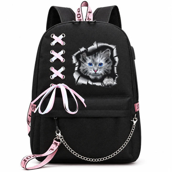 Black backpack with blue-eyed grey kitten print framed by cracked paper, pink-and-white ribbon bow and silver chain on white.