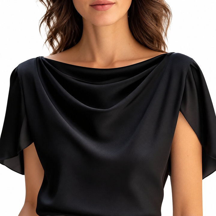 Closeup view of the black blouse showing front neckline folds and overlapping short sleeves against a white studio background