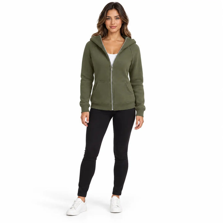 Studio model wearing the Olive Green zip hoodie, showing a front zipper, hood and ribbed cuffs, on white with black trousers.