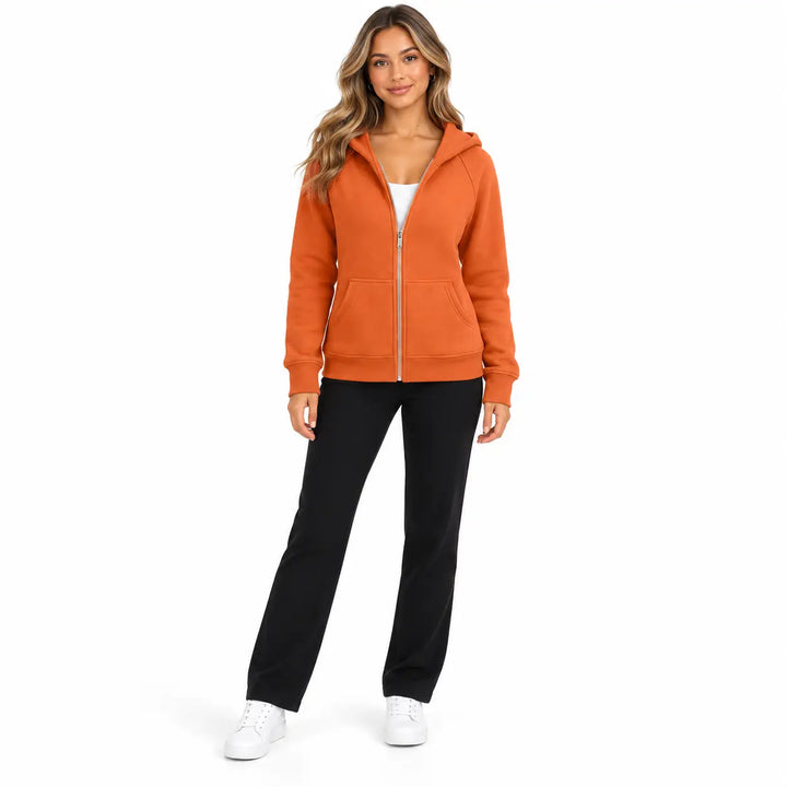 Full-body model wearing the Burnt Orange zip hoodie, showing front pockets, ribbed cuffs and hem, with soft shadows on white.