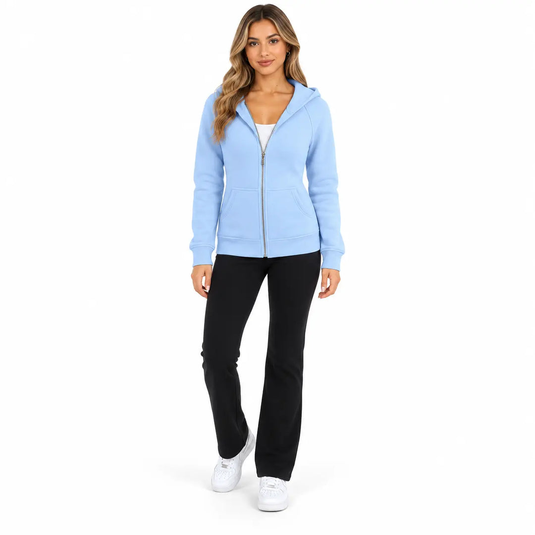 Full-body model wearing the Sky Blue zip hoodie, showing a front zipper, hood and ribbed cuffs, on white with black trousers.