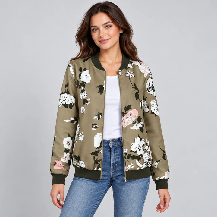 Studio model wearing the Army Green printed zip-up jacket with blue jeans, showing white flowers, pink accents and dark trim.