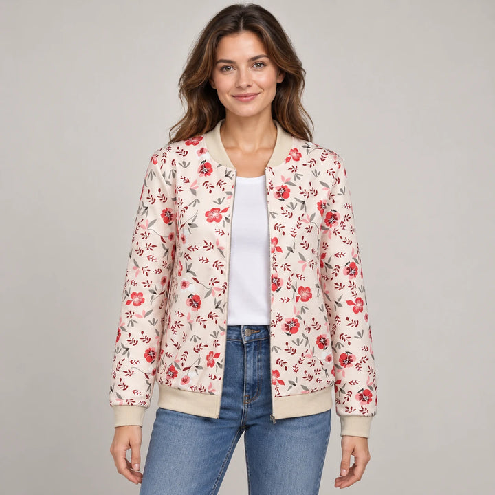 Studio model wearing the Pink floral bomber jacket over a white tee and blue jeans, with beige trim and both sleeves visible.