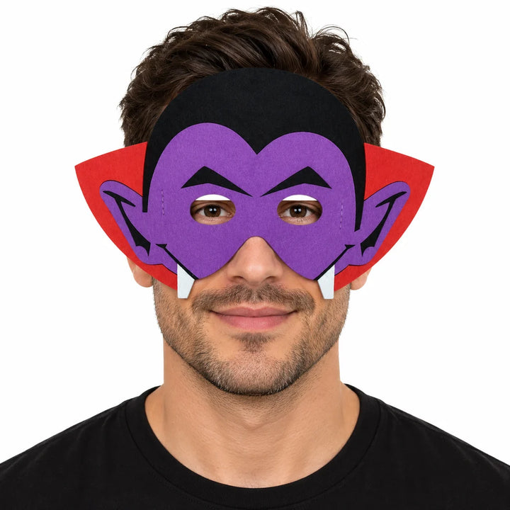 Adult male model wearing a purple vampire felt mask with black hair, red collar and white fang details on a white background.