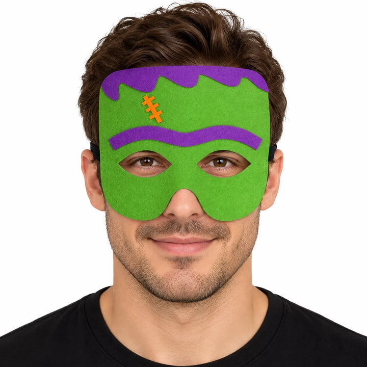 Adult male model wearing a green monster felt mask with purple hair, purple brow and orange stitch against a white background