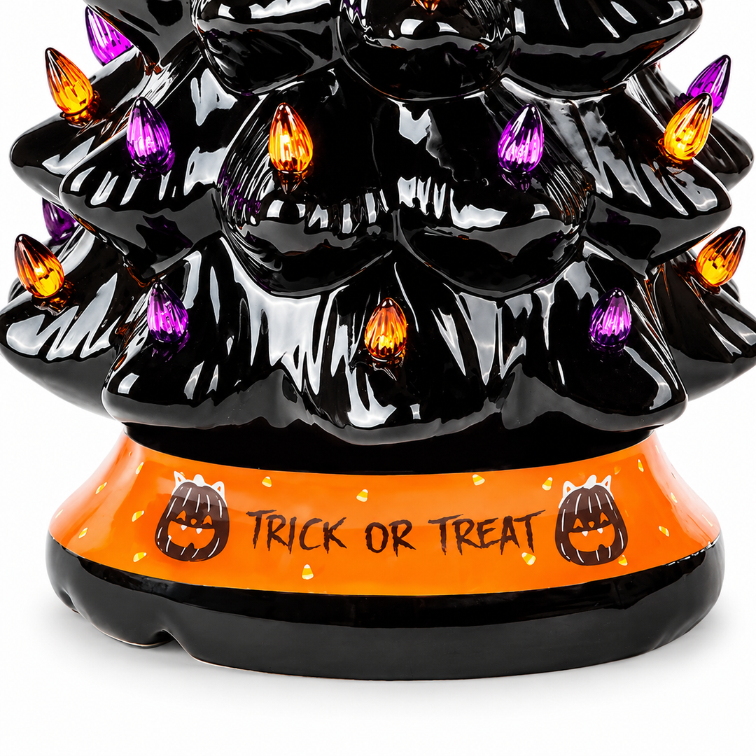 Close view of the orange TRICK OR TREAT tree base, two black pumpkin motifs and lower black tiers against a white background.