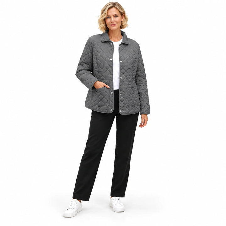 Gray quilted jacket on a full-body model wearing black trousers and white sneakers, showing the collar and the front pockets.