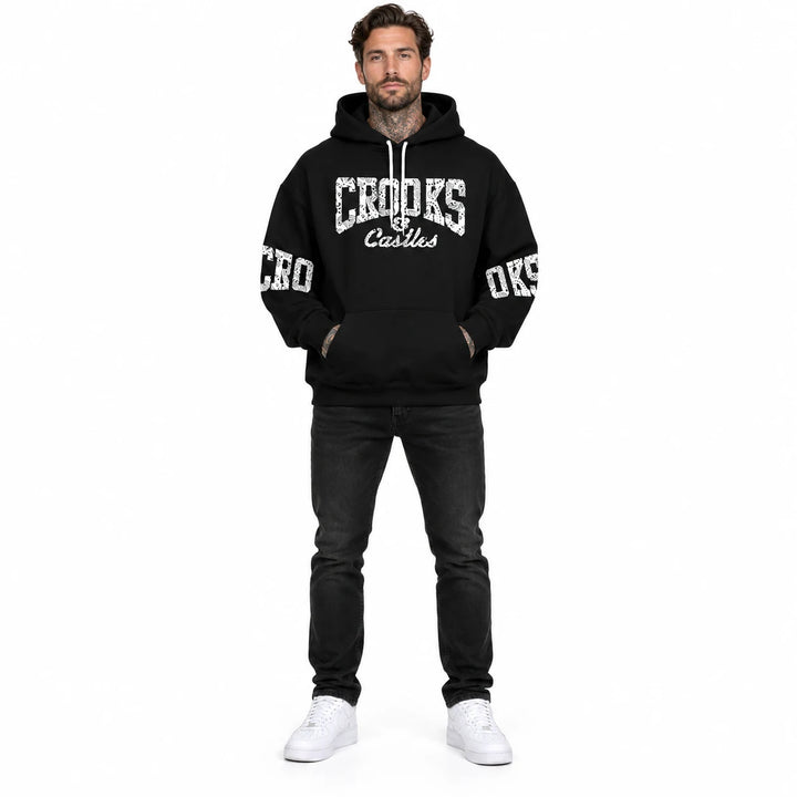 Full-length male model wearing a Black graphic hoodie with chest and sleeve prints on a white studio background