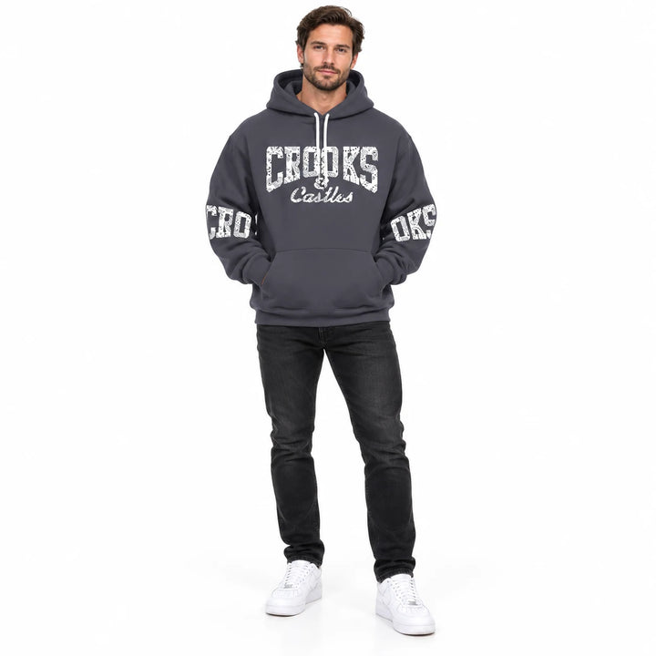 Full-length male model wearing a Charcoal graphic hoodie with chest and sleeve prints on a white studio background