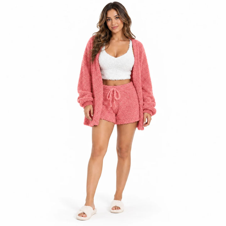 Studio model wearing a coral red coat and drawstring shorts with a white cropped vest, front view on white studio background.