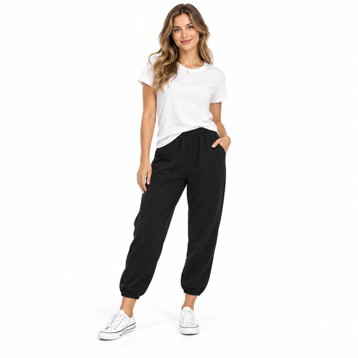 Black drawstring ankle pants on a standing adult woman, showing the ankle length and drawstring, on a plain white background.
