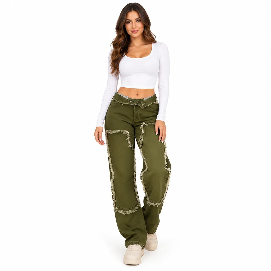 Relaxed studio pose of an adult model in Olive Green jeans with printed panel outlines, a white crop top and neutral footwear