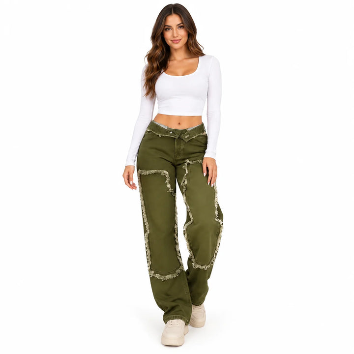 Relaxed studio pose of an adult model in Olive Green jeans with printed panel outlines, a white crop top and neutral footwear