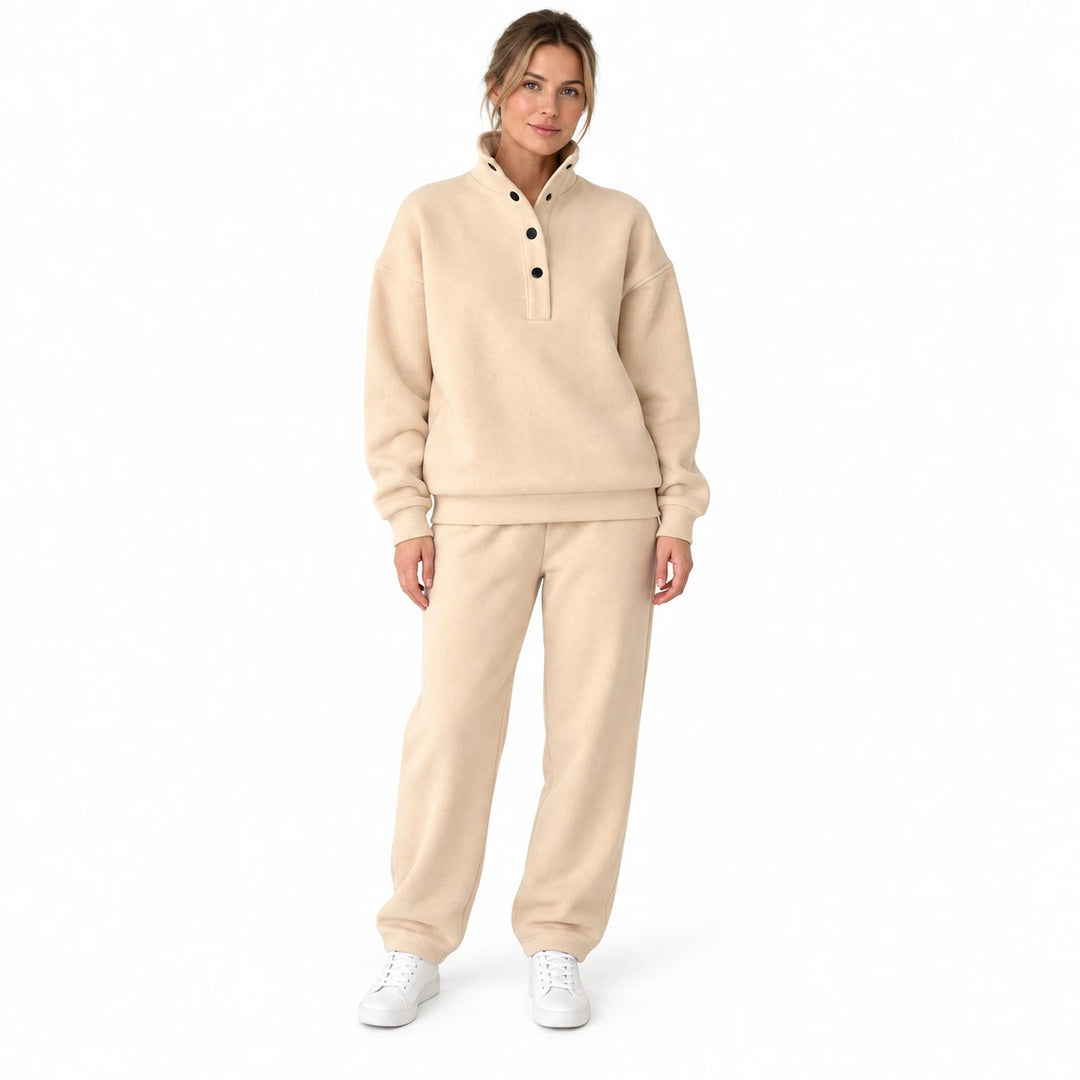 Beige pullover pants set with a stand collar and dark buttons, worn by an adult model in a standing pose on a white backdrop.