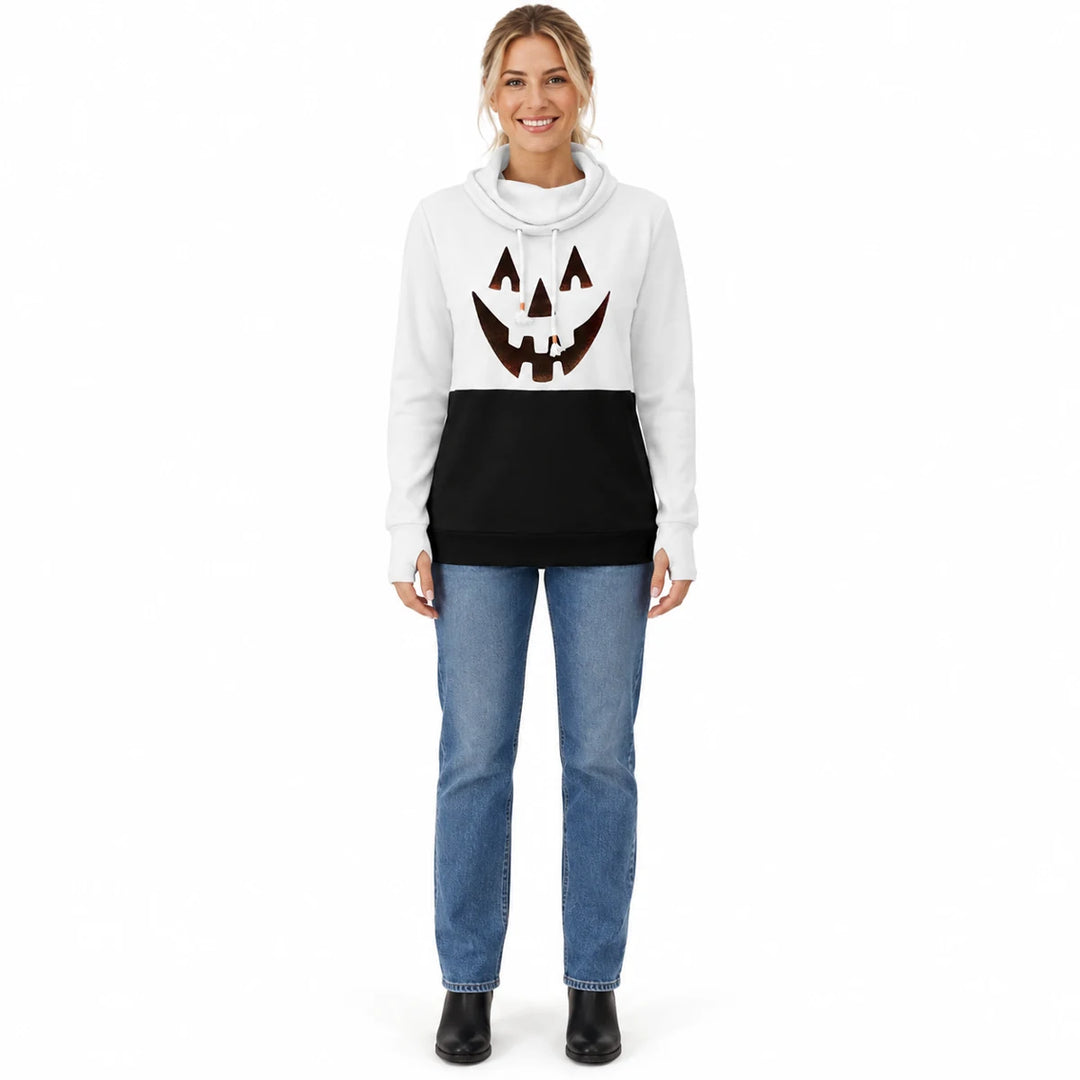 Woman wearing a white and black pumpkin print pullover with blue jeans and black ankle boots in a full-body studio front view