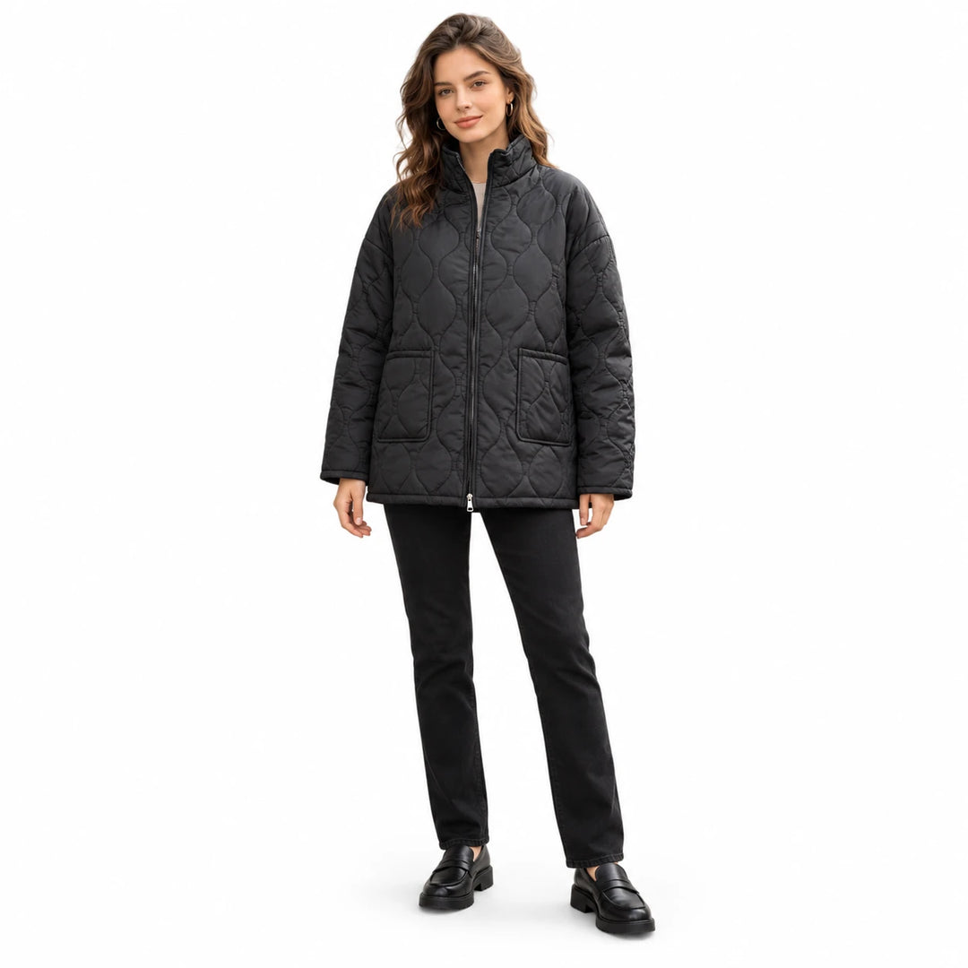 Plus size quilted coat in black with stand collar, zip front and two patch pockets, worn by a model in full body studio view.