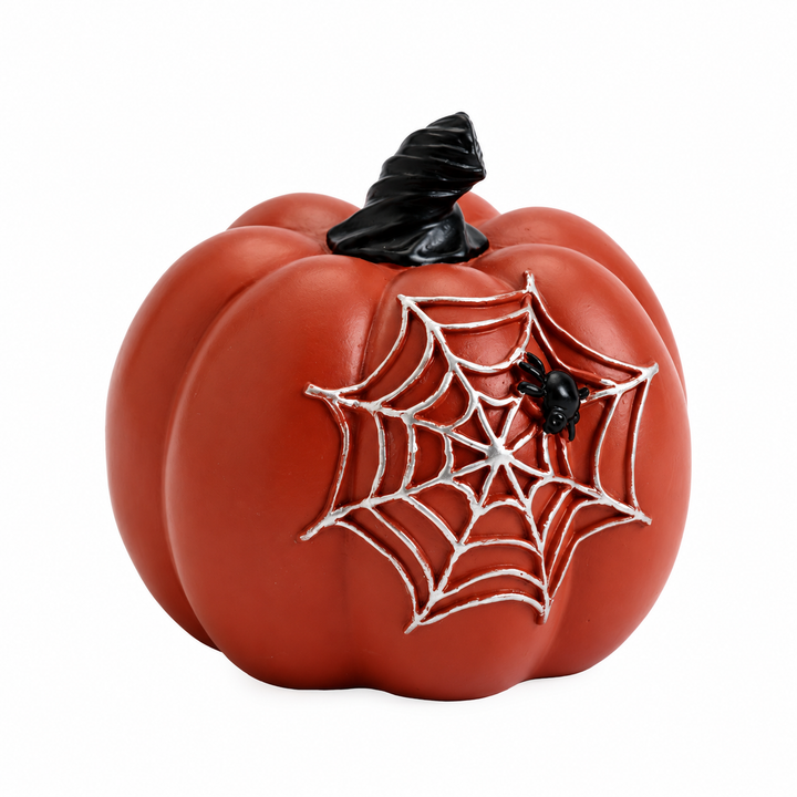 Reddish-brown pumpkin with pale raised spider web, tiny black spider and twisted dark stem, photographed on a white backdrop.