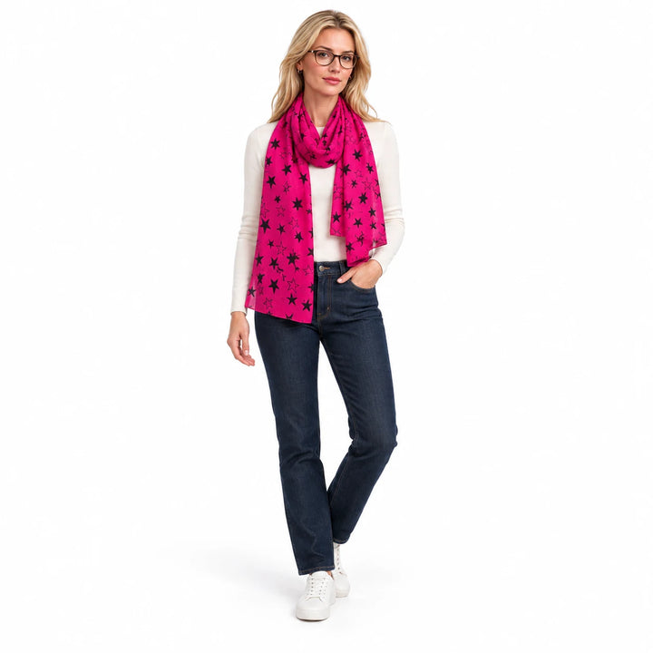 Fuchsia voile scarf on a full body woman model, with black stars and plain finished edges, against a white studio background.