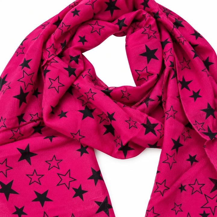 Fuchsia voile scarf shown in a close view of the print, showing solid and outlined black stars, on a white studio background.