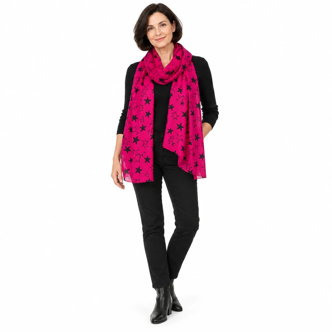 Fuchsia voile scarf on a full body woman model, with black stars and plain finished edges, against a white studio background.
