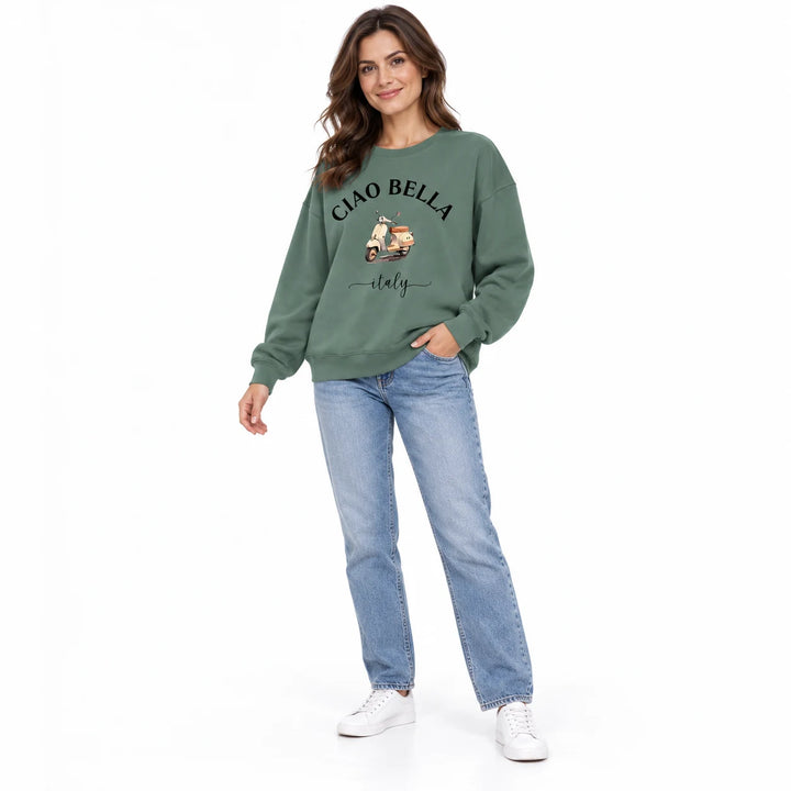 Olive green scooter print sweatshirt on a female model in an angled studio view, with loose sleeves and ribbed cuffs and hem.