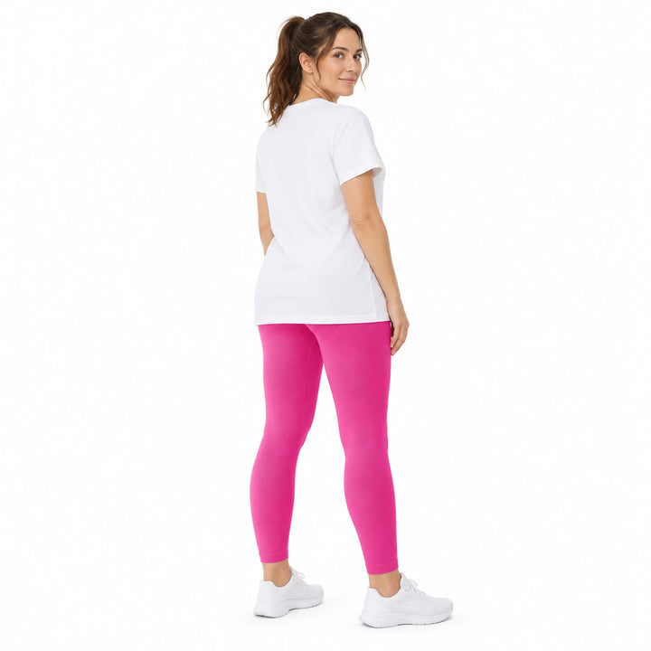 Adult model in Dragon Fruit high-waisted leggings, white longline T-shirt and white sneakers on a pure white studio backdrop.