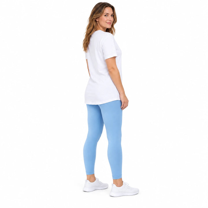 Adult model in Iceberg Blue high-waisted leggings, white longline T-shirt and white sneakers on a pure white studio backdrop.