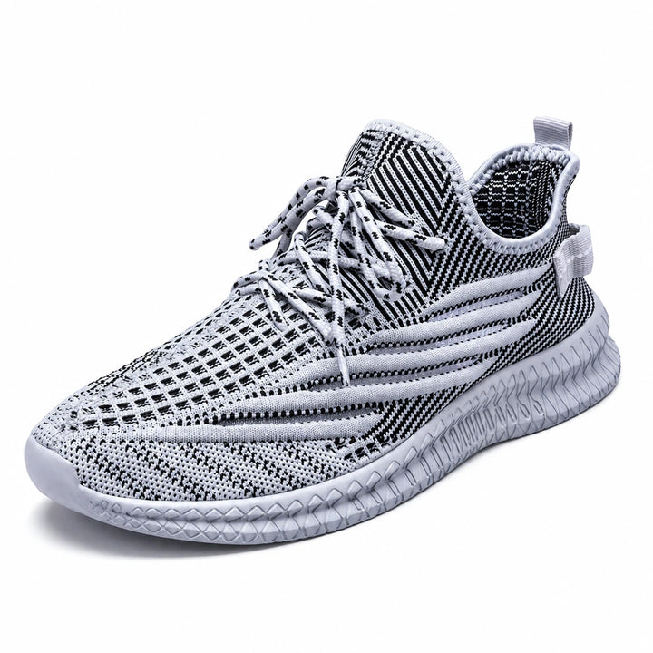 Gray mesh sneaker shown at a three-quarter angle, with striped knit, laces &amp; ribbed sole with white space around the subject.
