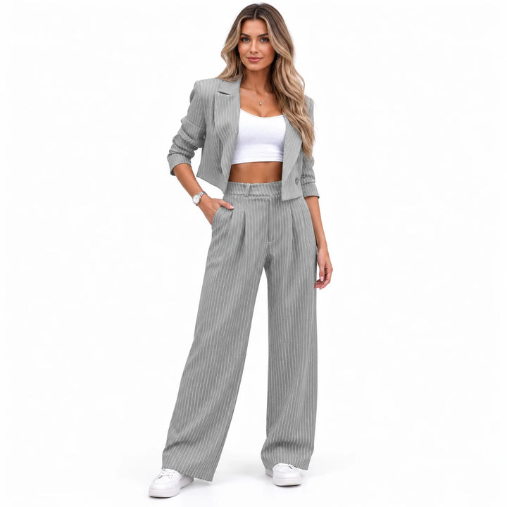 Gray matching set with a cropped lapel jacket, worn by an adult model in a standing pose on a seamless white studio backdrop.