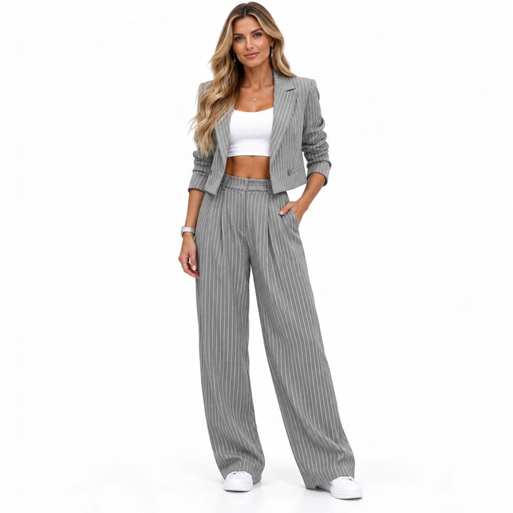 Gray matching set with a cropped lapel jacket, worn by an adult model in a standing pose on a seamless white studio backdrop.