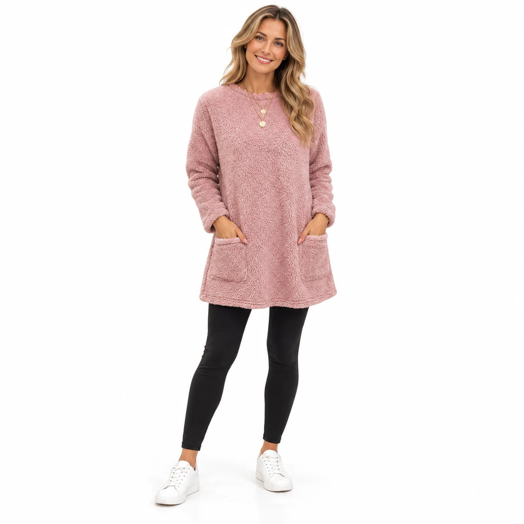 Pink long fleece pullover worn by an adult woman, with a round neck and front patch pockets, against a pure white background.