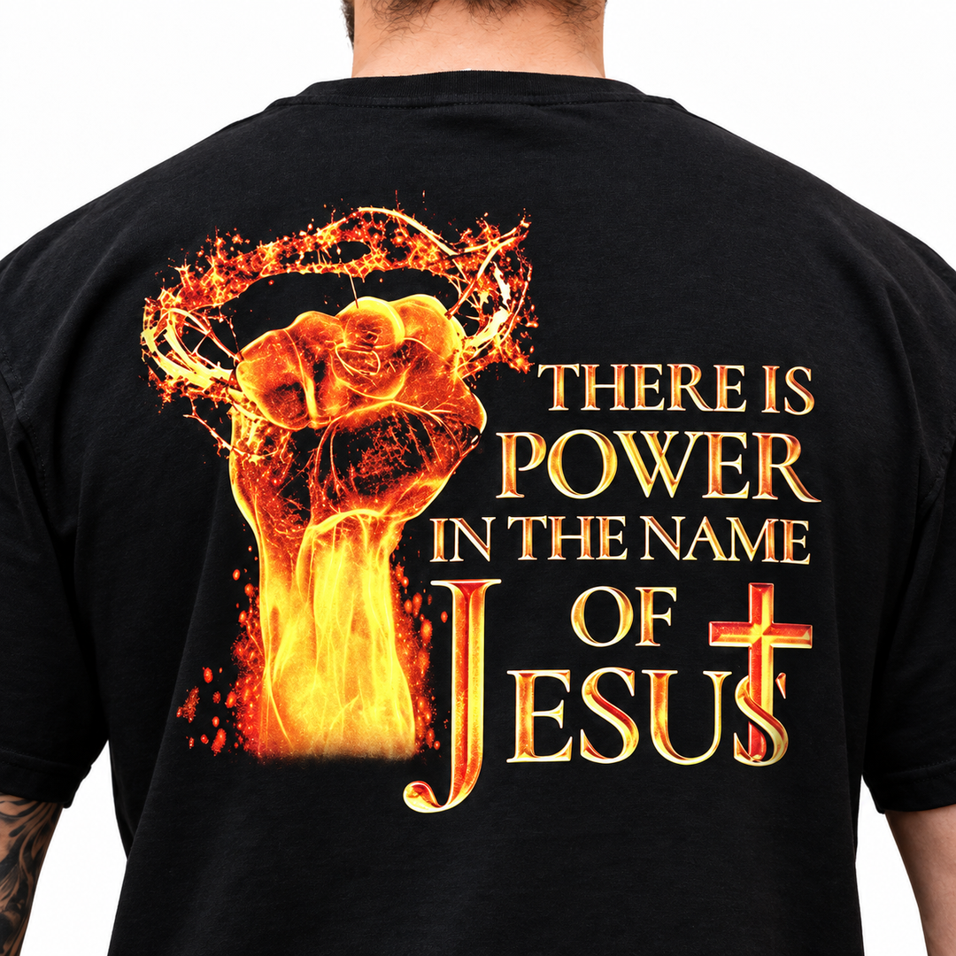 Close-up of black Christian T-shirt showing fiery THERE IS POWER IN THE NAME OF JESUS back graphic with detailed print and fabric texture.