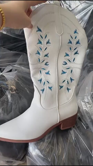Embroidered cowboy boots detail shot of stitched pattern on white shaft with pointed toe and high chunky heel
