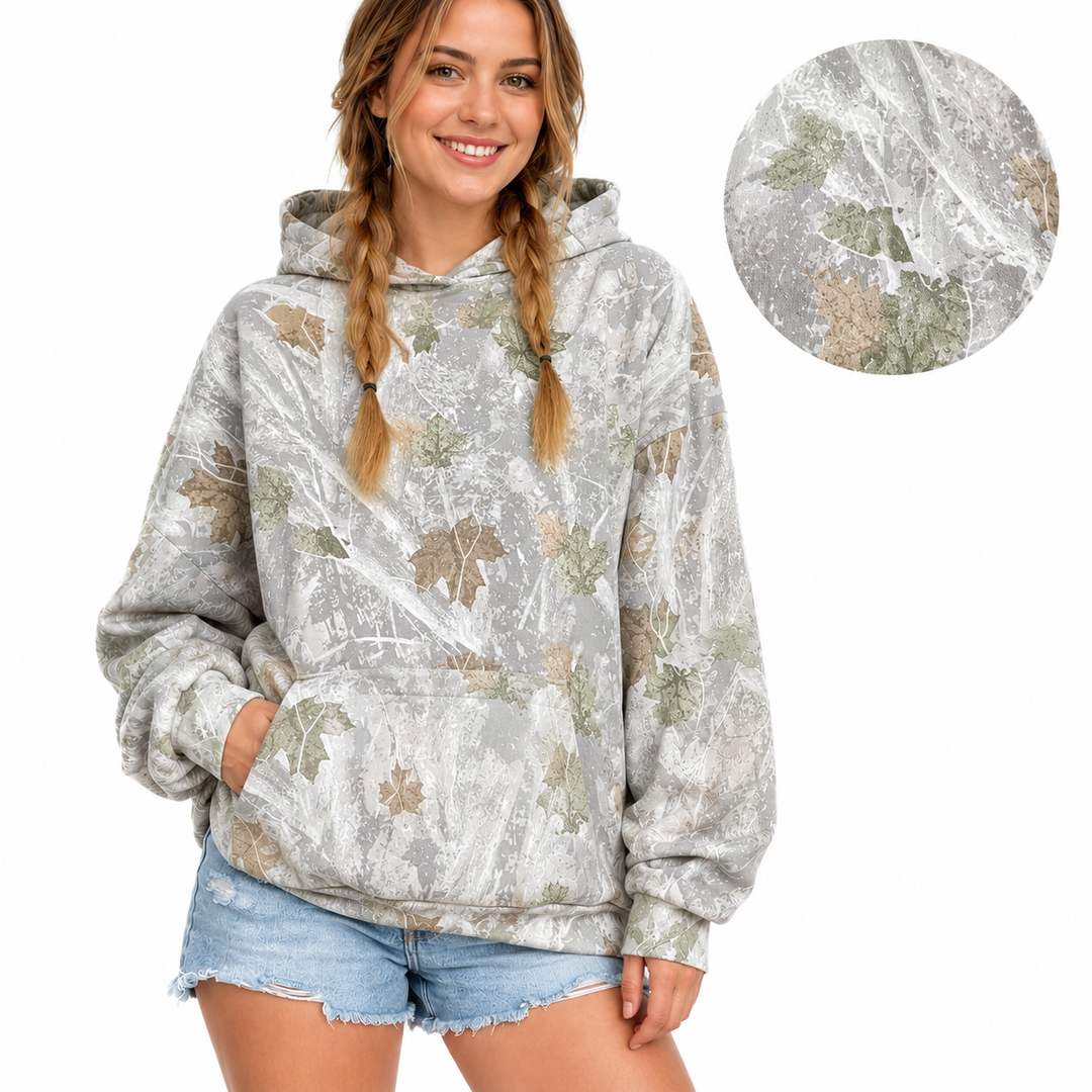 Printed pullover hoodie on a woman with a close inset of the mixed-color fabric pattern, presented on a white background.