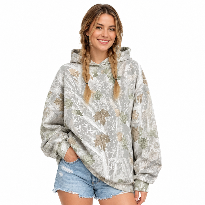 Printed pullover hoodie on a woman, front view showing hood, long sleeves and mixed-color leaf print on a white background.