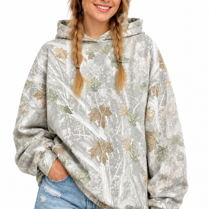 Woman wearing the printed pullover hoodie with the hood up, displaying the mixed-color print and long sleeves on white.
