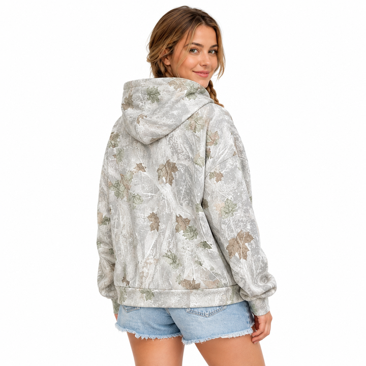 Side view of a woman wearing the printed pullover hoodie, showing the hood, long sleeve shape and mixed-color pattern.