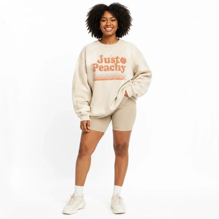 Printed sweatshirt for women in cream, front view with relaxed crew neck fit and Just Peachy graphic.