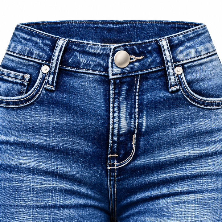 Close-up of blue denim waistband, front pocket stitching and metal button.