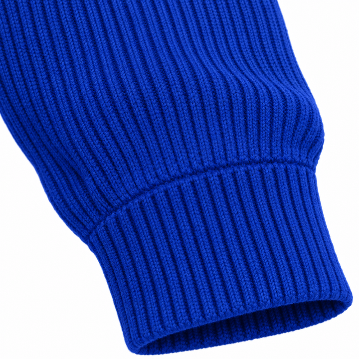 Close-up of sapphire blue ribbed sleeve cuff and adjacent knit texture.