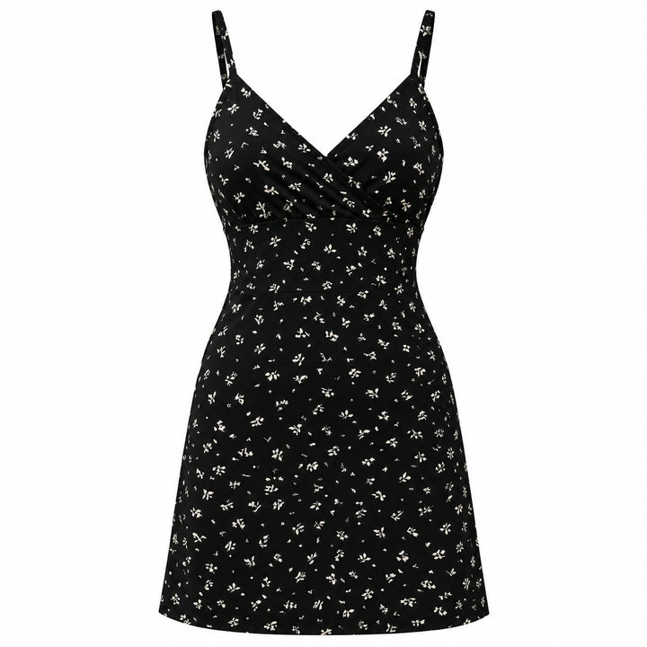 Black mini dress with a small light botanical print, wrap V neckline and thin straps, shown from the front on white.