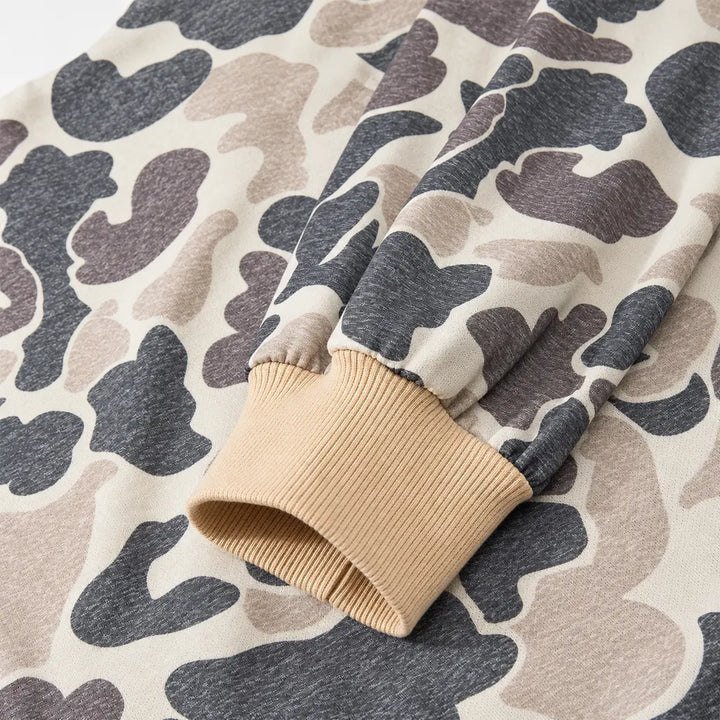 Details of the beige ribbed cuff and long camouflage sleeve, showing gathered fabric, stitching and the printed knit texture.