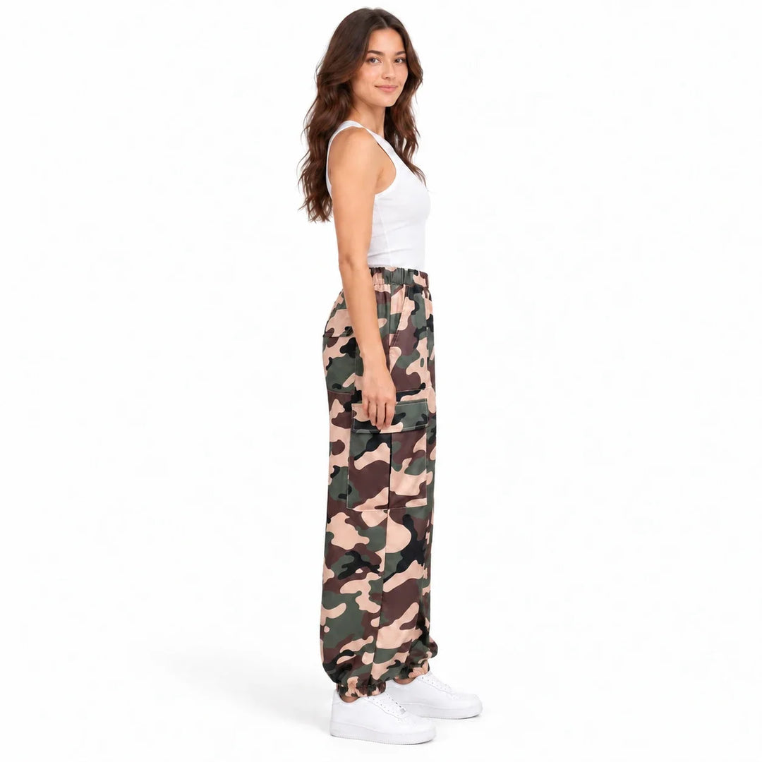 Side view of the model wearing Army Green Camouflage cargo pants, with a white tank, white shoes and the side pocket visible.