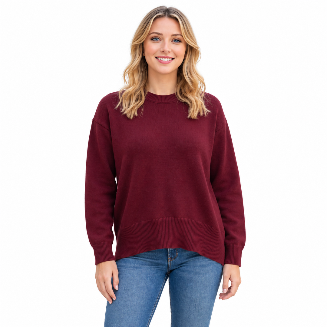 Wine Red knitted pullover on a model in a white studio, showing long sleeves, ribbed cuffs, a round neckline and relaxed fit.