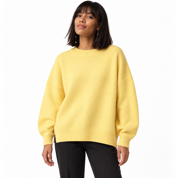 Yellow knitted pullover on a model in a white studio, with a crew neckline, dropped shoulders, long sleeves and ribbed edges.
