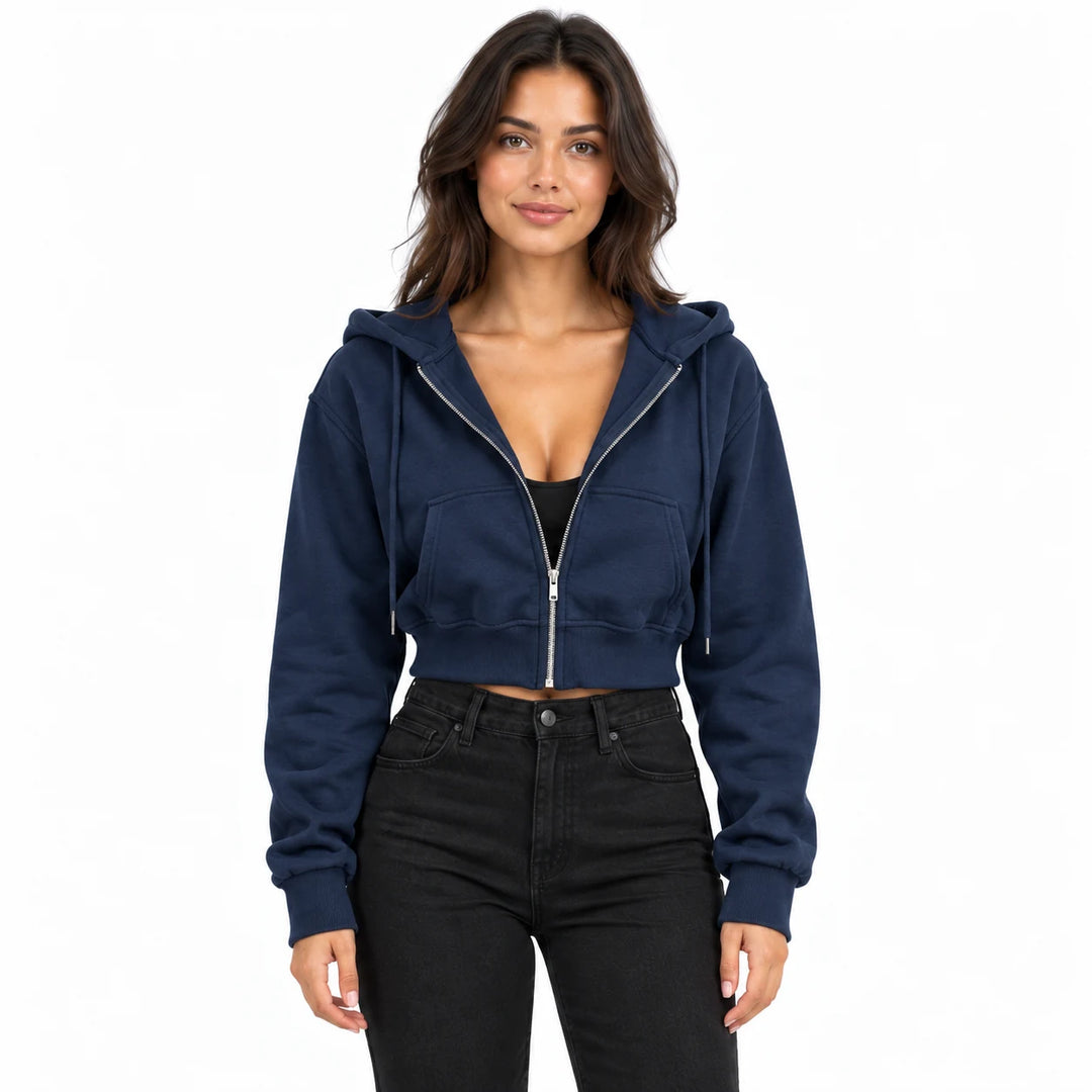 Navy blue hoodie on a model in an upper-body studio view, showing split front pockets, long sleeves and a cropped ribbed hem.